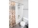 Cozy bathroom with a shower-tub combination featuring a patterned curtain and a standard white toilet at 10447 Pintail Ln, Indianapolis, IN 46239