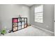 Neutral bedroom featuring a window and a black bookshelf with colorful storage cubes and toys at 10447 Pintail Ln, Indianapolis, IN 46239