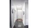 Hallway featuring dark wood-style flooring leading to a white front door, an office and a bathroom at 10447 Pintail Ln, Indianapolis, IN 46239