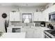 Bright kitchen with white cabinetry, stainless steel appliances, and a gray tile backsplash at 10447 Pintail Ln, Indianapolis, IN 46239
