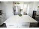 Kitchen island with stainless steel refrigerator and green plant atop the white countertop at 10447 Pintail Ln, Indianapolis, IN 46239