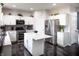 Kitchen featuring white cabinets, stainless steel appliances, a center island and dark wood-style floors at 10447 Pintail Ln, Indianapolis, IN 46239