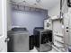 Functional laundry room with modern washer and dryer units and shelving for storage at 10447 Pintail Ln, Indianapolis, IN 46239