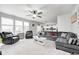 Spacious living room featuring neutral carpet, ample seating, ceiling fan, and natural light at 10447 Pintail Ln, Indianapolis, IN 46239