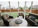Relaxing screened-in patio with wicker furniture, including chairs and a table with a built-in fire pit at 10447 Pintail Ln, Indianapolis, IN 46239
