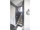 Carpeted staircase with dark accent wall and bright lighting, leading to the upper level of the home at 10447 Pintail Ln, Indianapolis, IN 46239