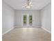 Spacious, light-filled room with French doors leading to the outdoor balcony and wood-look flooring at 11226 Blackwalnut Pt, Indianapolis, IN 46236
