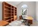 Bright home office featuring custom built-in shelving, large window and a modern desk at 11226 Blackwalnut Pt, Indianapolis, IN 46236