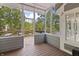 Charming sunroom with wood flooring, framed by scenic lake views and ample natural light at 11226 Blackwalnut Pt, Indianapolis, IN 46236