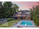 Impressive backyard with a large pool, stone patio, lush lawn, and mature trees at 11715 Landings Dr, Indianapolis, IN 46256