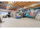 Unfinished basement space with painted mural, storage, and access to patio at 11715 Landings Dr, Indianapolis, IN 46256