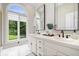 Bright bathroom featuring dual sinks, ample counter space, and a large window providing natural light at 11715 Landings Dr, Indianapolis, IN 46256