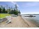 Private beach area featuring white Adirondack chairs and direct access to the lake at 11715 Landings Dr, Indianapolis, IN 46256