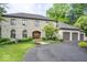 Stunning stone-clad home featuring an arched entry, meticulously manicured landscaping, and an attached three-car garage at 11715 Landings Dr, Indianapolis, IN 46256