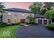 Elegant stone home with manicured lawn, curved driveway, and a three-car garage at 11715 Landings Dr, Indianapolis, IN 46256