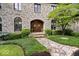 Stone front of home with a stone walkway leading to the arched wood front door and landscaping at 11715 Landings Dr, Indianapolis, IN 46256
