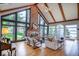 Bright living room featuring a soaring brick fireplace, hardwood floors, and expansive windows with lake views at 11715 Landings Dr, Indianapolis, IN 46256