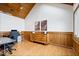 Home office featuring hardwood floors, wood paneling, a vaulted ceiling, and ample natural light at 11715 Landings Dr, Indianapolis, IN 46256