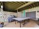 Outdoor patio with a ping pong table and views of the stone wall and garage door at 11715 Landings Dr, Indianapolis, IN 46256
