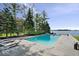 Luxury pool area with stone patio surrounded by tall trees, next to the lake at 11715 Landings Dr, Indianapolis, IN 46256