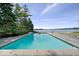 Beautiful in-ground pool with a lake view, surrounded by mature trees and landscaping at 11715 Landings Dr, Indianapolis, IN 46256