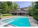 Gorgeous stone home featuring a pristine pool with diving board, surrounded by lush landscaping at 11715 Landings Dr, Indianapolis, IN 46256