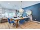 Inviting dining area with a modern table and blue velvet chairs, flowing into a living room with accent wall at 13217 E 131St St, Fishers, IN 46037