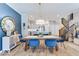 Elegant dining area with accent wall, featuring a table with chairs and seamlessly connected to a modern kitchen and staircase at 13217 E 131St St, Fishers, IN 46037