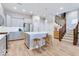 Well-lit kitchen with a large island, stainless steel appliances, and hardwood floors with staircase to the second floor at 13217 E 131St St, Fishers, IN 46037