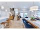 Open-concept living space featuring pendant lights over kitchen island, staircase, and a dining table with plush blue chairs at 13217 E 131St St, Fishers, IN 46037
