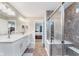 Beautiful bathroom featuring a double vanity, walk-in shower, and access to the bedroom at 14075 Knightstown E Dr, Carmel, IN 46033