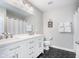 Bright bathroom featuring a double vanity, dark flooring, and white shaker cabinets at 14075 Knightstown E Dr, Carmel, IN 46033