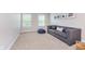Comfortable living room with neutral carpet, gray sofa, and natural lighting at 14075 Knightstown E Dr, Carmel, IN 46033
