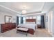 Elegant main bedroom with tray ceiling, chandelier, wood furniture, and soft lighting at 14075 Knightstown E Dr, Carmel, IN 46033