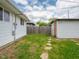 View of the house's backyard with a wooden fence and stone pathway leading to shed at 1415 Lawton Ave, Indianapolis, IN 46203