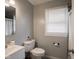 Cozy bathroom with a gray wall, white fixtures, and natural light from the window at 1415 Lawton Ave, Indianapolis, IN 46203
