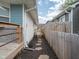 Exterior view of the side yard with stone pathway, wooden fence and a glimpse of blue siding at 1415 Lawton Ave, Indianapolis, IN 46203