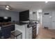Open concept kitchen featuring a breakfast bar with modern countertops, a stainless steel range, and an adjacent living area at 1415 Lawton Ave, Indianapolis, IN 46203