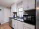 A well lit kitchen featuring white cabinets, stainless steel appliances, and tile backsplash at 1415 Lawton Ave, Indianapolis, IN 46203
