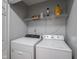Well-lit laundry room featuring a Whirlpool washer and dryer with storage shelves at 1415 Lawton Ave, Indianapolis, IN 46203