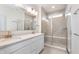 Bathroom featuring double sinks, granite countertops, a large mirror, and a glass walk-in shower at 14515 Hanford Ln, Carmel, IN 46074