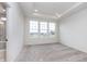 Bright bedroom featuring a tray ceiling, plush carpet, and three large windows letting in natural light at 14515 Hanford Ln, Carmel, IN 46074