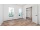 Sunlit bedroom with two windows, wood-look floors, and white trim at 14515 Hanford Ln, Carmel, IN 46074