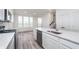 Kitchen with island, stainless steel dishwasher and range, white cabinets and hardwood floors at 14515 Hanford Ln, Carmel, IN 46074