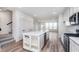 Bright kitchen with a center island, white cabinets, stainless steel appliances, and hardwood floors at 14515 Hanford Ln, Carmel, IN 46074