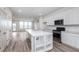 Light-filled kitchen with island, stainless steel appliances, white cabinetry, and access to the living room at 14515 Hanford Ln, Carmel, IN 46074