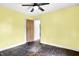 Bedroom with yellow walls and dark hardwood floors is brightly lit by a ceiling fan at 1523 E Mills Ave, Indianapolis, IN 46227