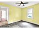 Cozy bedroom featuring natural light, yellow walls, and a ceiling fan at 1523 E Mills Ave, Indianapolis, IN 46227