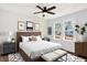 Stylized bedroom featuring a queen-sized bed, ceiling fan and bright windows at 1523 E Mills Ave, Indianapolis, IN 46227