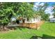A charming home with a wooden ramp, surrounded by lush greenery, creating a serene atmosphere at 1523 E Mills Ave, Indianapolis, IN 46227